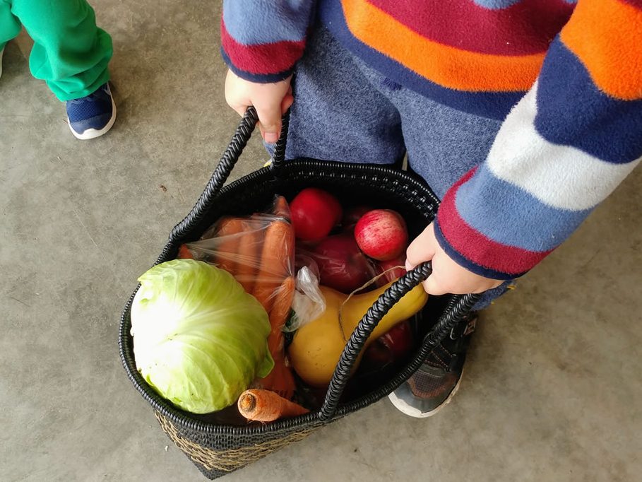 Child with Veggies at Farm Stand