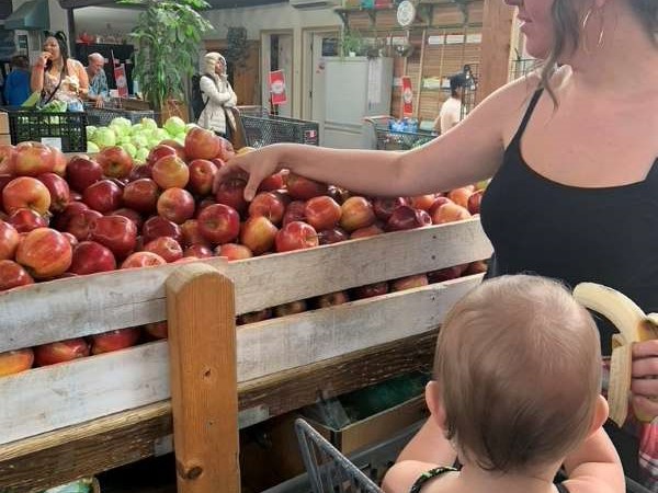 Client Choosing Apples with Baby